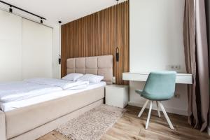 a bedroom with a bed and a desk and a blue chair at VIP Apartments in Lviv