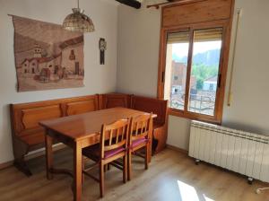 comedor con mesa, sillas y ventana en Cala Monica, en Camarasa