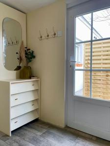 een kamer met een deur, een dressoir en een spiegel bij Maison centre bourg de Baden in Baden