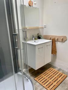 een badkamer met een witte wastafel en een douche bij Maison centre bourg de Baden in Baden