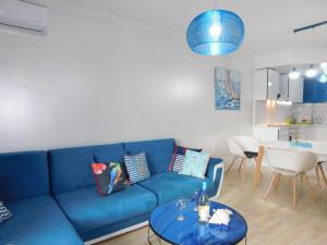 a blue couch in a living room with a table at Azzurro Sarafovo in Burgas City