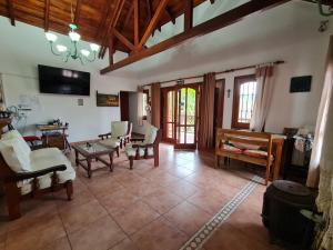 una gran sala de estar con sillas y mesa. en Cabanas Las Pencas, HOSTERIA en Mina Clavero