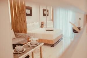 Aelia - Luxury Central Suite في أليكساندروبولي: غرفة بسرير واريكة وطاولة