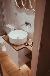 Aelia - Luxury Central Suite في أليكساندروبولي: حمام مع حوض أبيض ومرحاض