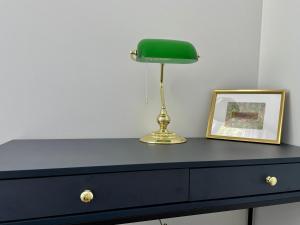 a blue dresser with a green lamp and a picture at Lux New Port in Gdańsk