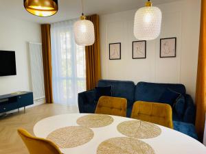 a living room with a table and a blue couch at Lux New Port in Gdańsk