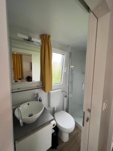 a bathroom with a white toilet and a sink at LunaBay SpiritoS Mobile Home, Terra Park SpiritoS in Kolan