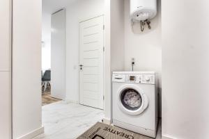 a white laundry room with a washing machine at VIP Apartments in Lviv
