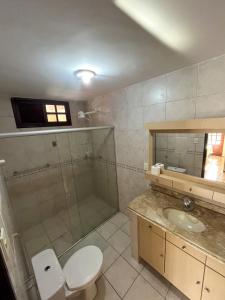 een badkamer met een douche, een toilet en een wastafel bij Pousada Recanto de Ponta Negra in Natal