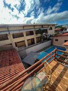 een balkon met een parasol en een zwembad bij Pousada Recanto de Ponta Negra in Natal