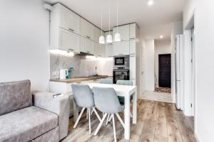 a kitchen and living room with a table and chairs at VIP Apartments in Lviv