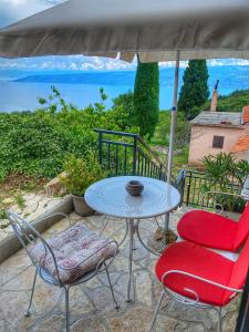 a patio with a table and two chairs and an umbrella at Holiday Home Istra in Plomin
