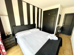 Dormitorio con cama con pared de rayas en blanco y negro en ALMA BEACH ESTARTIT en L'Estartit