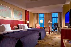 a hotel room with two beds and a flat screen tv at Sheraton Guiyang Hotel in Guiyang