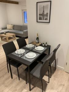a black dining room table with chairs and a couch at Apartment mit Jacuzzi Enschede 10km in Gronau