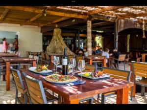una mesa de madera con dos platos de comida y copas de vino en LunaBay SpiritoS Mobile Home, Terra Park SpiritoS en Kolan