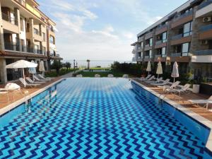 a swimming pool in the middle of two buildings at Azzurro Sarafovo in Burgas City