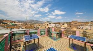 a balcony with two tables and a view of a city at Riad Fes Hayat in Fez