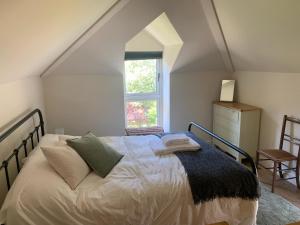 a bedroom with a large bed with a window at Maristow Cottages, overlook Tamar Valley Dartmoor in Plymouth