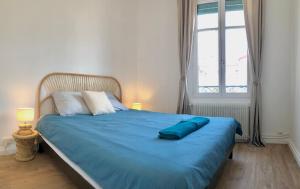 a bedroom with a blue bed with a large window at HYPER-CENTRE-PLAGE - 46m2 - 2 pieces - Rénové 2023 in Saint-Jean-de-Luz