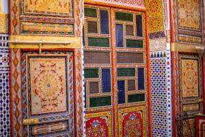 una pared con muchos tipos diferentes de puertas coloridas en Riad Fes Hayat, en Fez