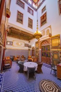 a room with tables and chairs and a ceiling at Riad Fes Hayat in Fez