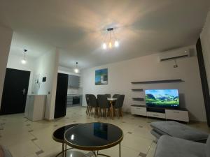 uma sala de estar com um sofá, uma mesa e uma televisão em Xh&S apartment em Durrës