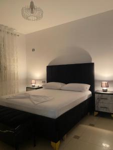 um quarto com uma cama grande e uma cabeceira preta em Xh&S apartment em Durrës