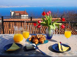 een tafel met een bord eten en sinaasappelsap bij House Aronia in Lovran