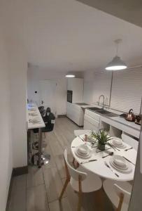 a kitchen with a table and some chairs and a table and a counter at Three bedroom House in London