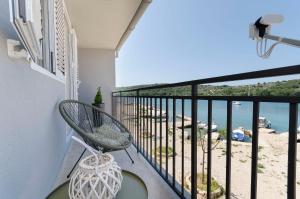 a balcony with a chair and a view of the beach at Apartment Little Paradise in Kaprije