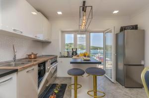 a kitchen with a counter and two stools in it at Apartment Little Paradise in Kaprije