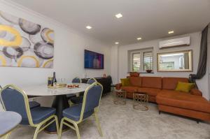 ein Wohnzimmer mit einem Sofa und einem Tisch in der Unterkunft Apartment Little Paradise in Kaprije
