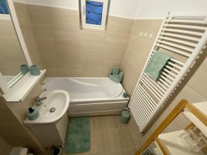 un piccolo bagno con vasca e lavandino di JACOBS LUXURY Apartaments a Râmnicu Vâlcea