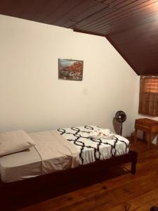 a bedroom with a bed and a picture on the wall at Hostal Dilu Boquete in Bajo Boquete
