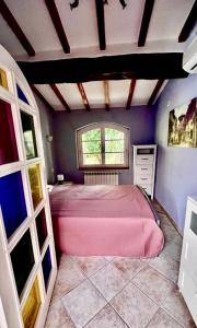 um quarto com uma cama rosa e uma janela em Casa Piccolo Paradiso em Giuncarico