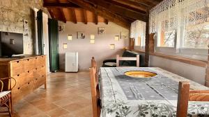 um quarto com uma mesa e uma cozinha com uma televisão em Casa Piccolo Paradiso em Giuncarico