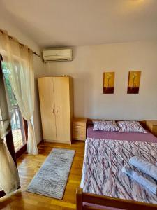 a bedroom with two beds and a cabinet and a window at Apartment City Center in Ulcinj