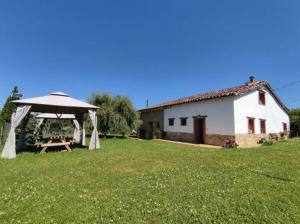 een achtertuin met een tent en een tafel in het gras bij Sagasta Rural - Oviedo in Oviedo