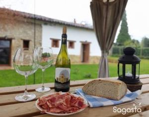 een tafel met een fles wijn en twee glazen bij Sagasta Rural - Oviedo in Oviedo