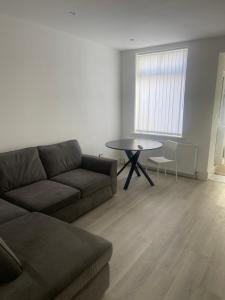 - un salon avec un canapé et une table dans l'établissement Flat 1 15 woodland Road, m18 7HS, à Manchester