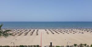a beach with a lot of chairs and the ocean at Xh&S apartment in Durrës