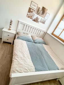 a white bed in a room with a window at Deine Auszeit in Eggesin