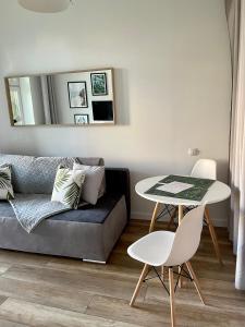een woonkamer met een bank en een tafel bij Komfortowo Plus in Gdynia