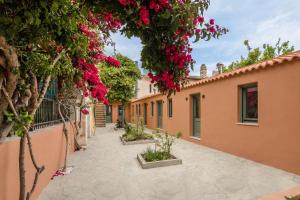 um pátio de uma casa com flores cor-de-rosa em Lindas Convent Garden Home 1 em Chania Town