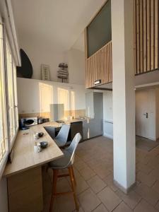 a kitchen with a table and chairs in a room at Malo, Duplex bord de mer accès direct plage en rdc in Dunkerque