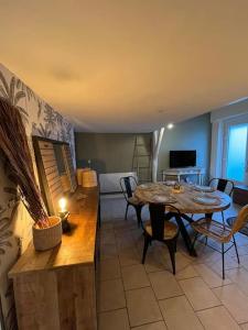 ein Esszimmer mit einem Tisch und Stühlen sowie ein Wohnzimmer in der Unterkunft Malo, Duplex bord de mer accès direct plage en rdc in Dunkerque