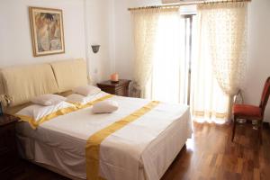 - une chambre avec un lit blanc et une couverture jaune dans l'établissement Luxury Apartment, near Pinikoudes beach, à Larnaka