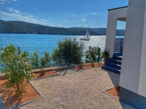 a house with a view of a sail boat on the water at Bella Homes Camping in Tisno