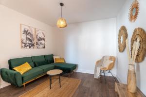 uma sala de estar com um sofá verde e uma mesa em Atlantic Selection - L'Apaisant au centre de Dax em Dax